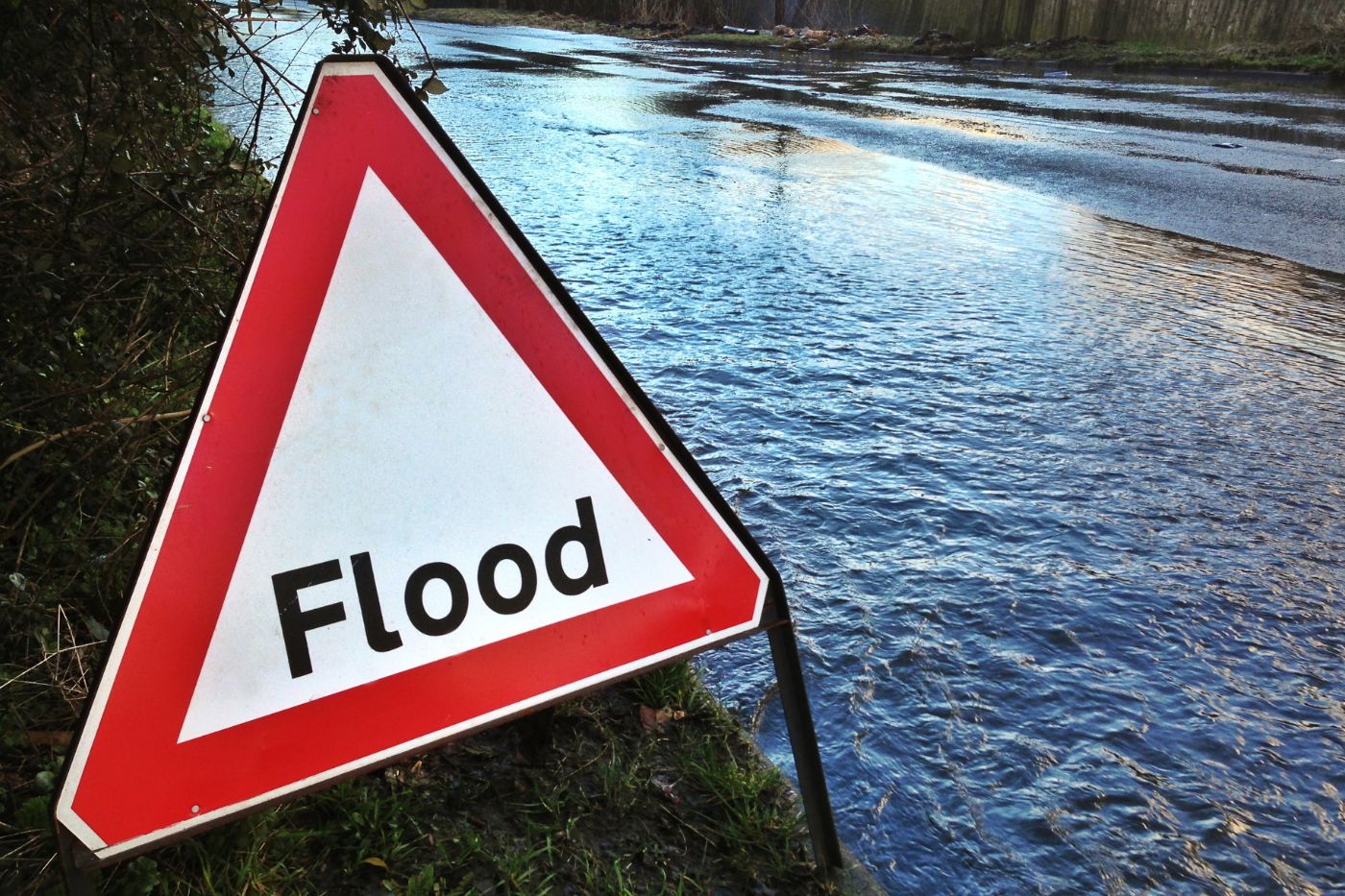 A photo of flood waters and a Flood sign